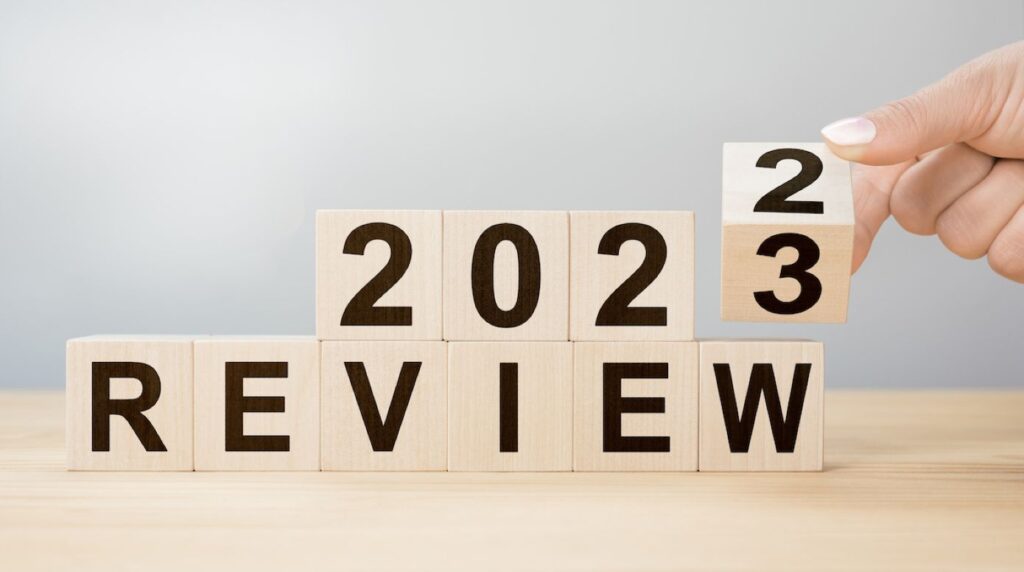 2023-review-new-year-business-concept-planning-2023-businessman-hand-flips-wooden-cube-changes-inscription-review-2022-review-2023-new-year-resolution (1)